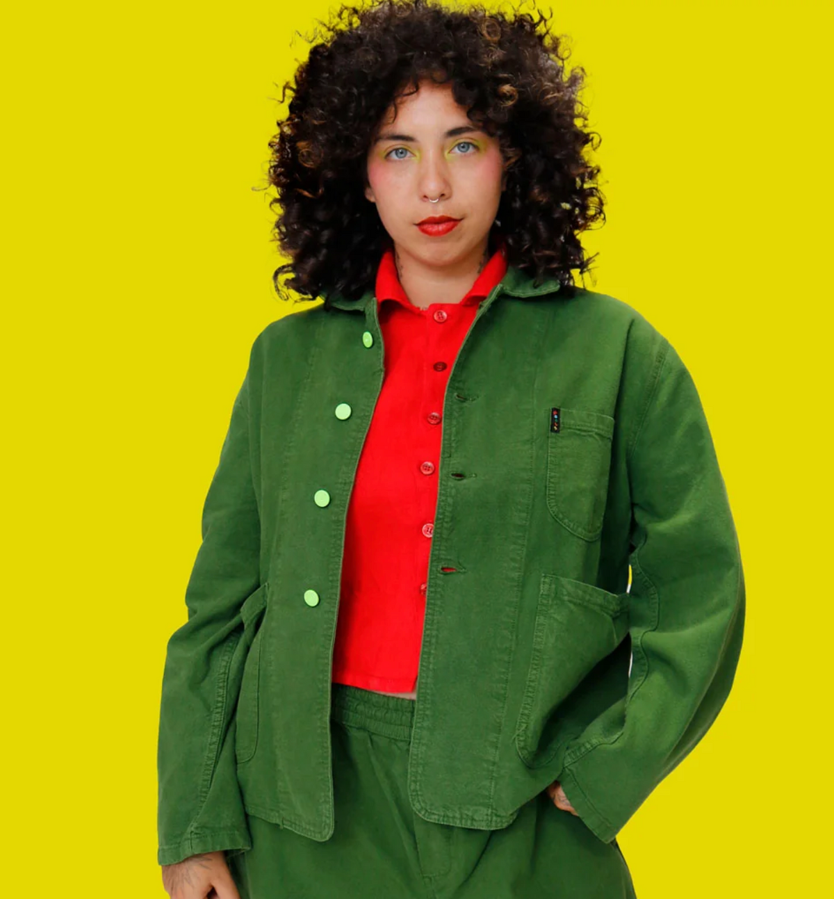 jacket paired w red shirt on model with yellow background