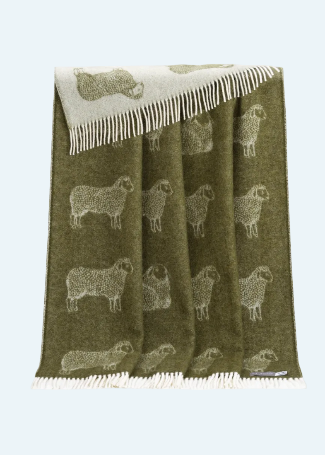 green throw with white fringe and sheep