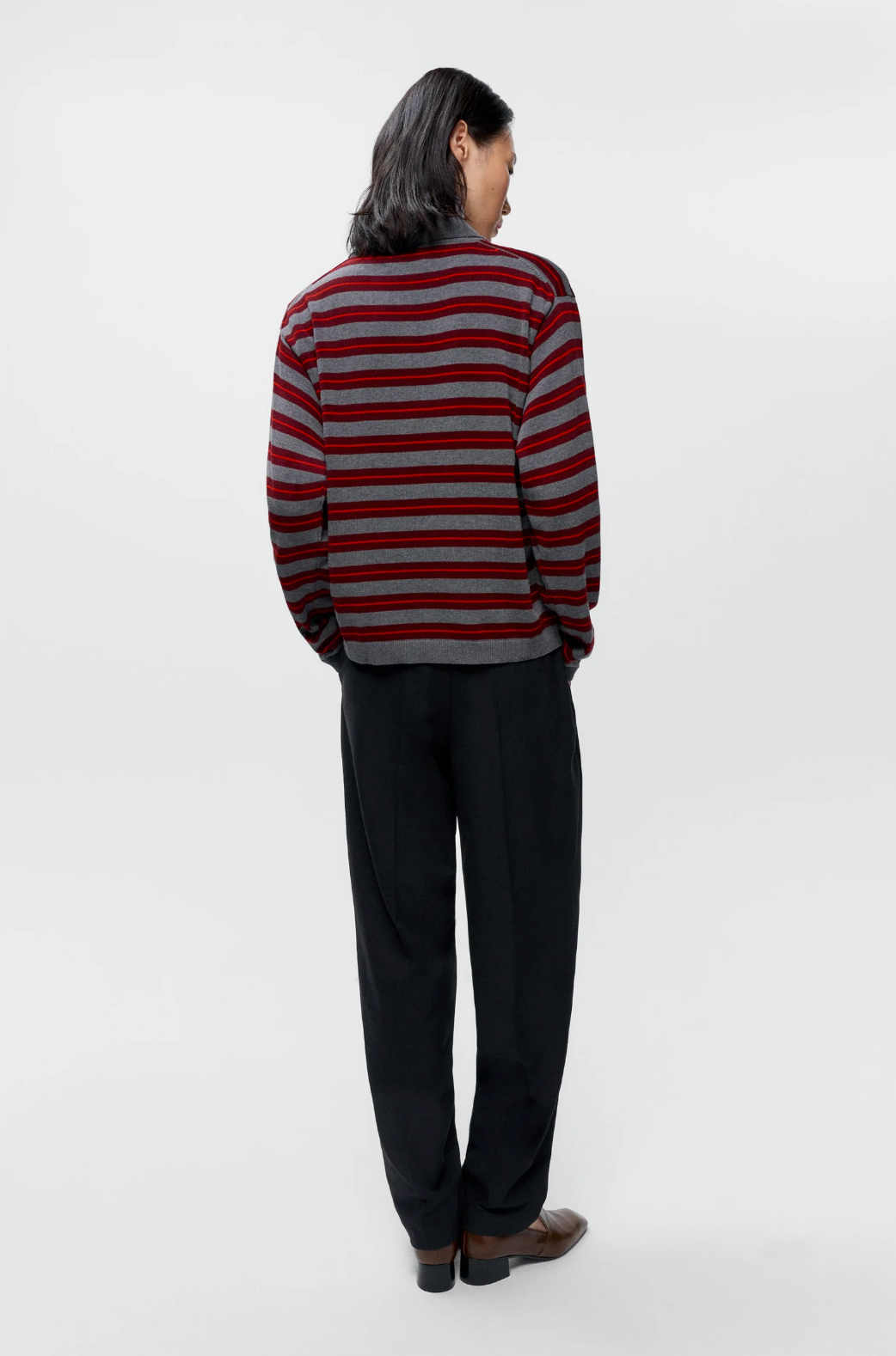 grey and red striped polo on model wearing black pants 