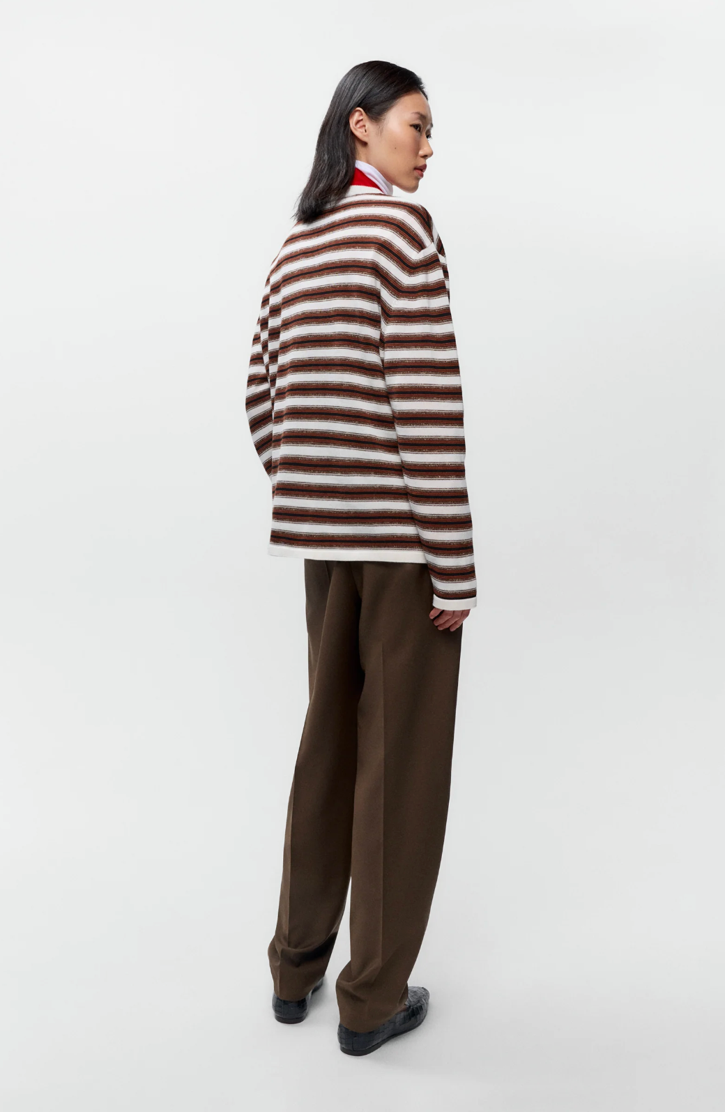 brown, black and white striped long sleeve t shirt on model with brown pants from back