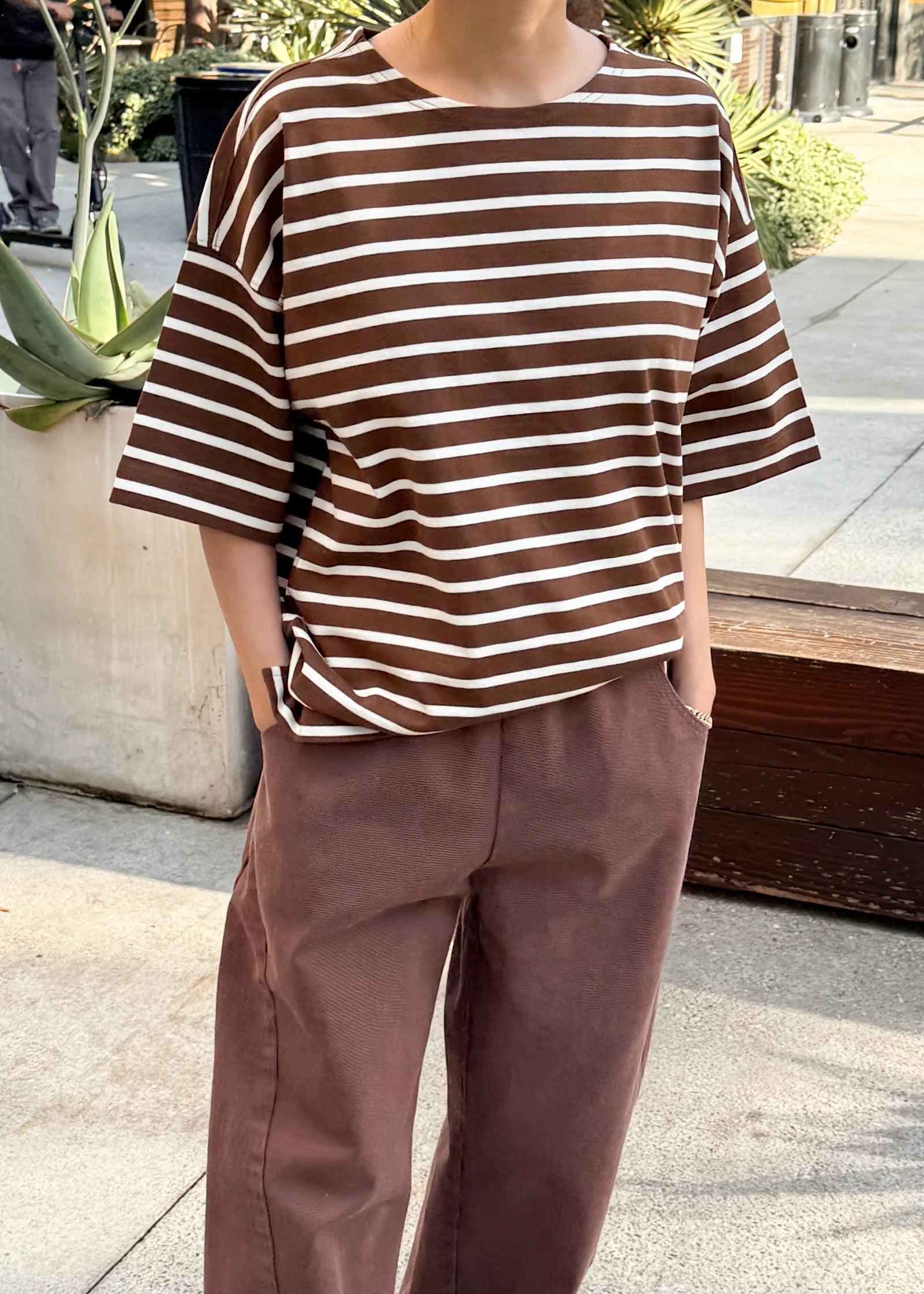 person wearing brown and white striped t shirt and brown pants