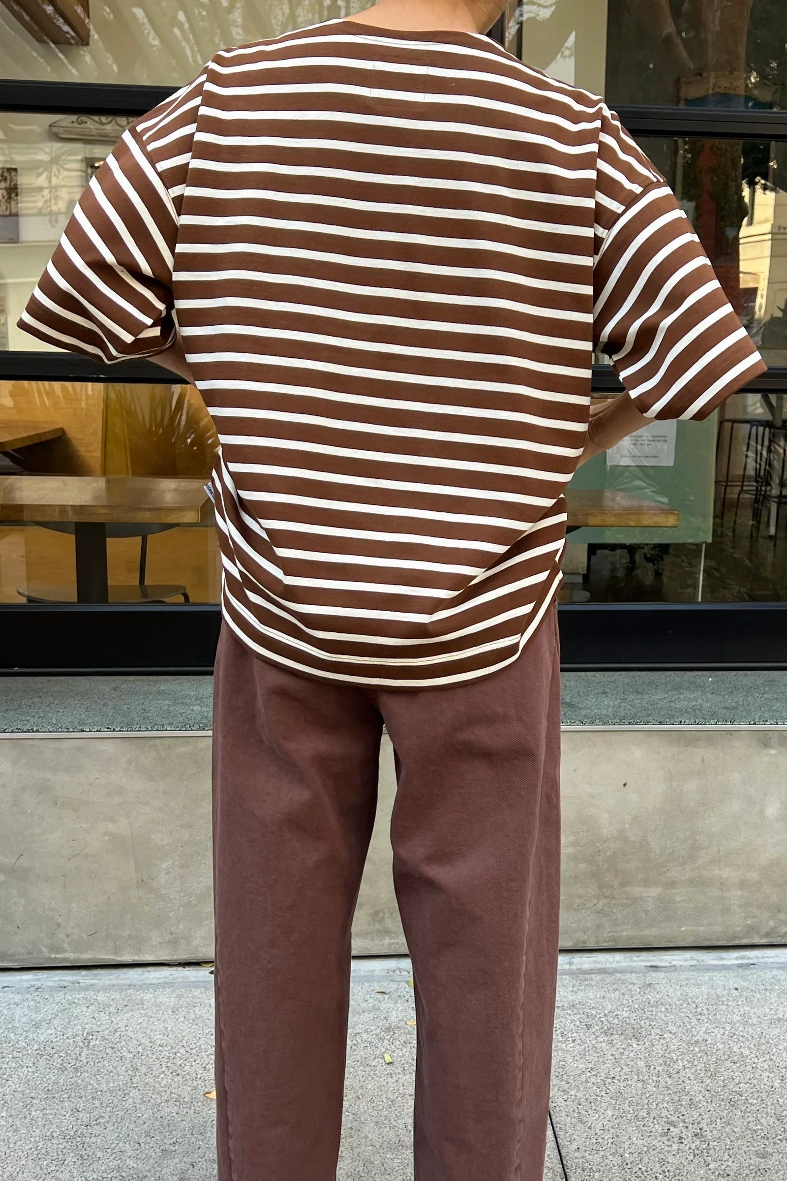 person wearing brown and white striped t shirt and brown pants