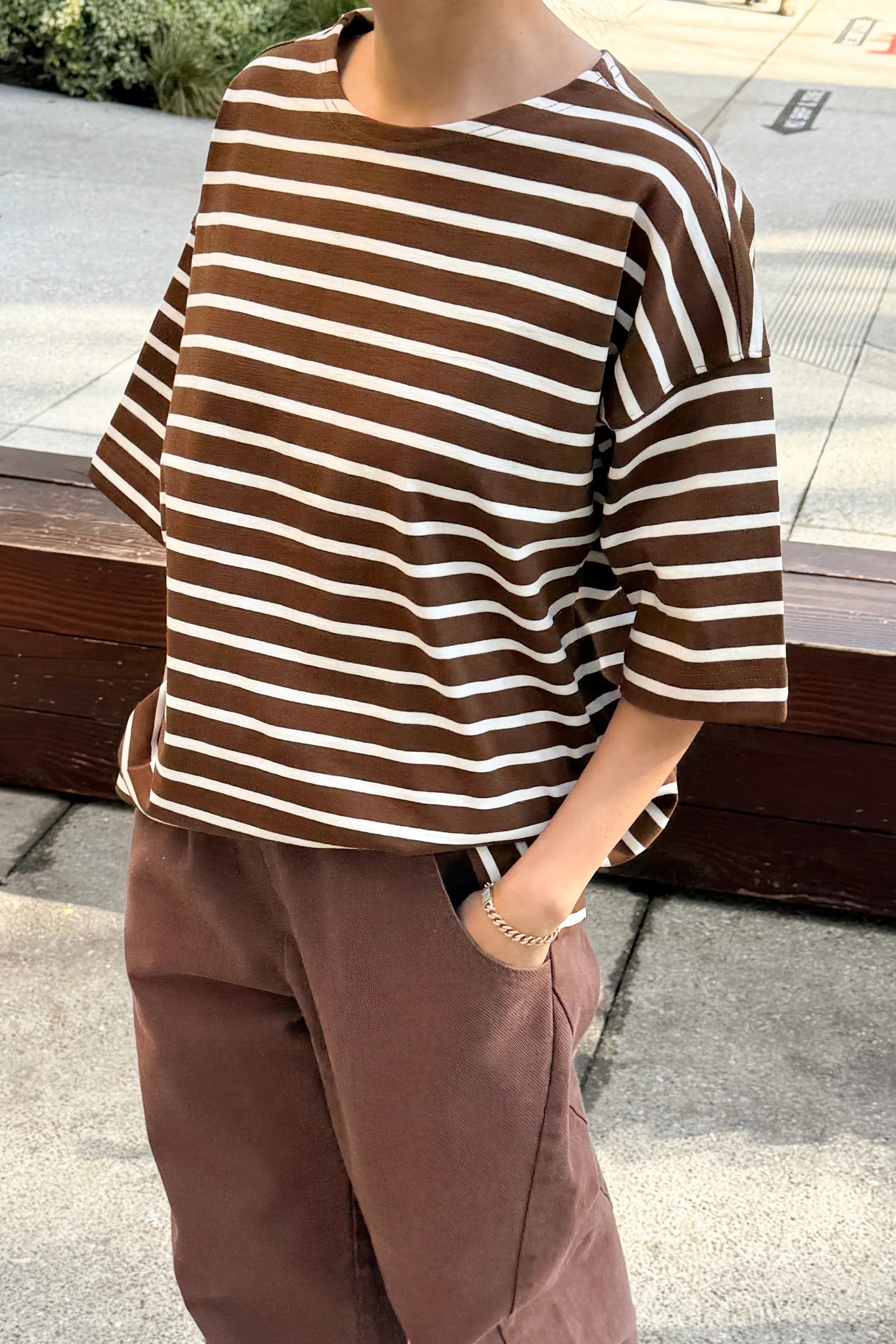 person wearing brown and white striped t shirt and brown pants