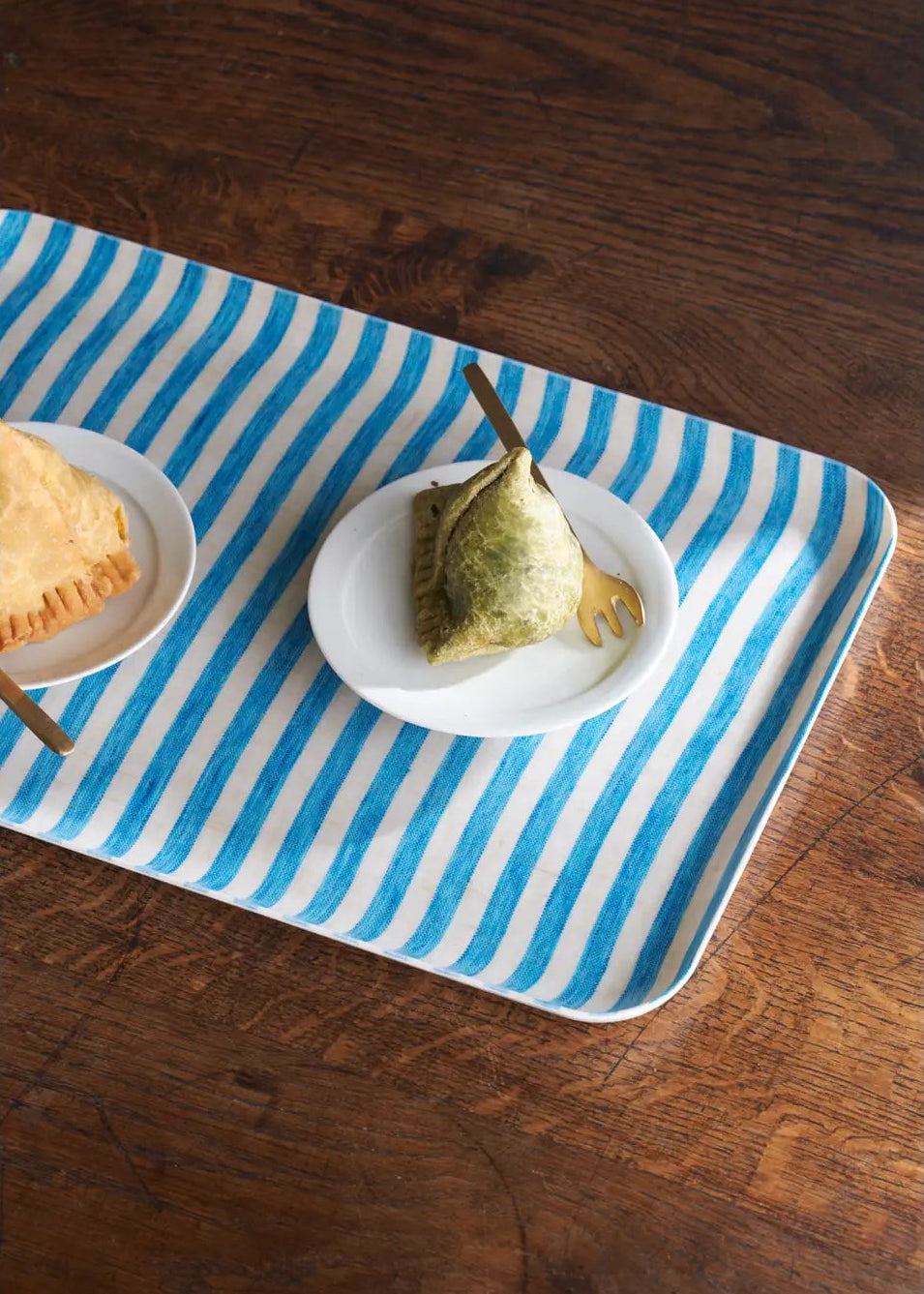 Rectangular tray with blue and white stripes on a wooden surface