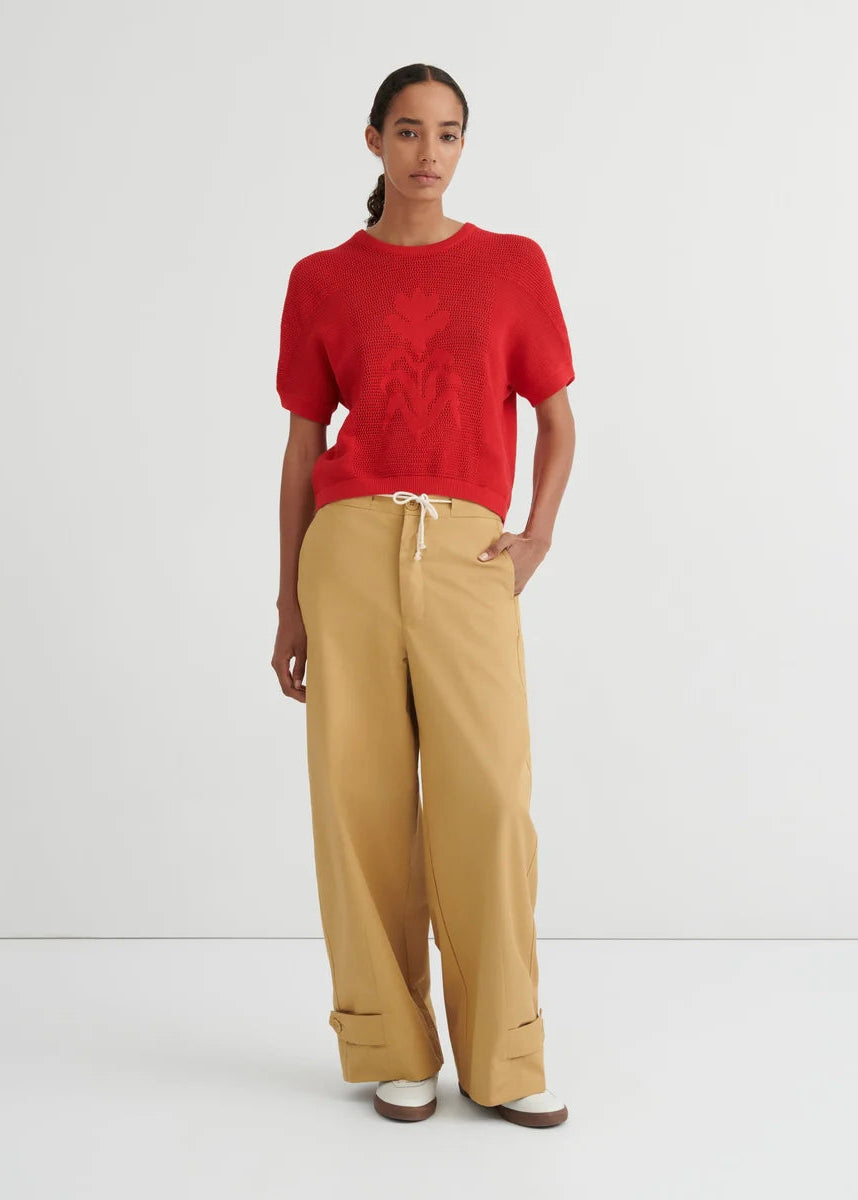 red short sleeve sweater and tan pants on model