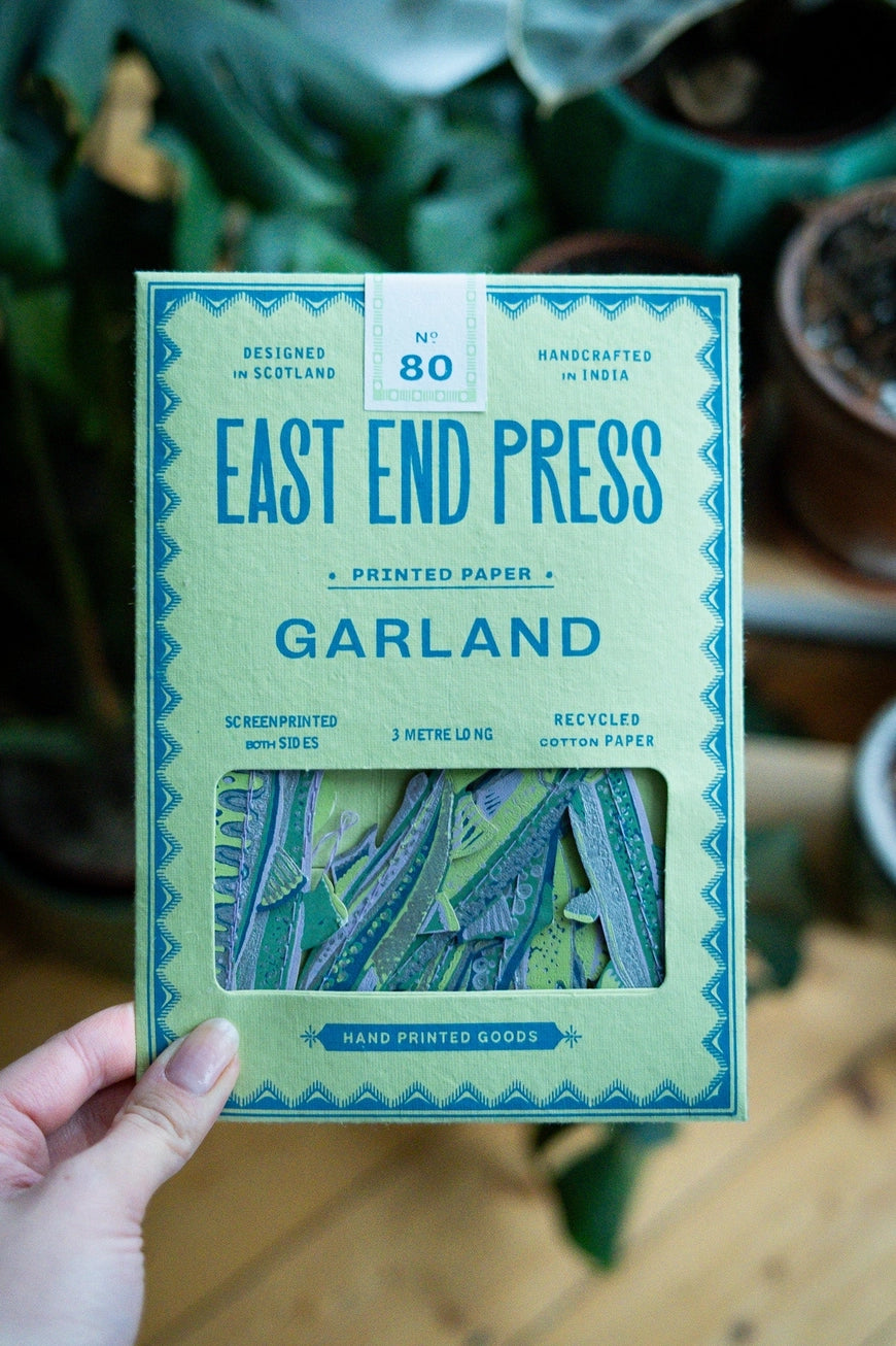 Packaged product from East End Press held by a hand with a blurred indoor background