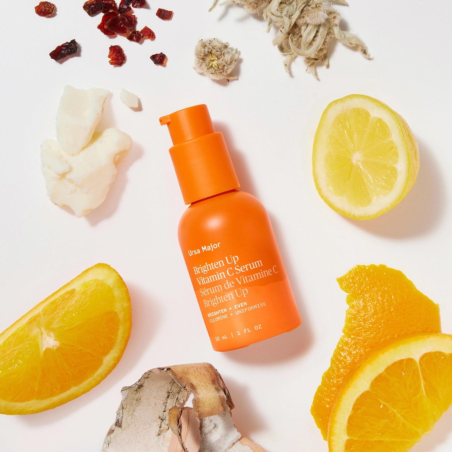 Orange serum bottle with lemon and orange slices on a white background