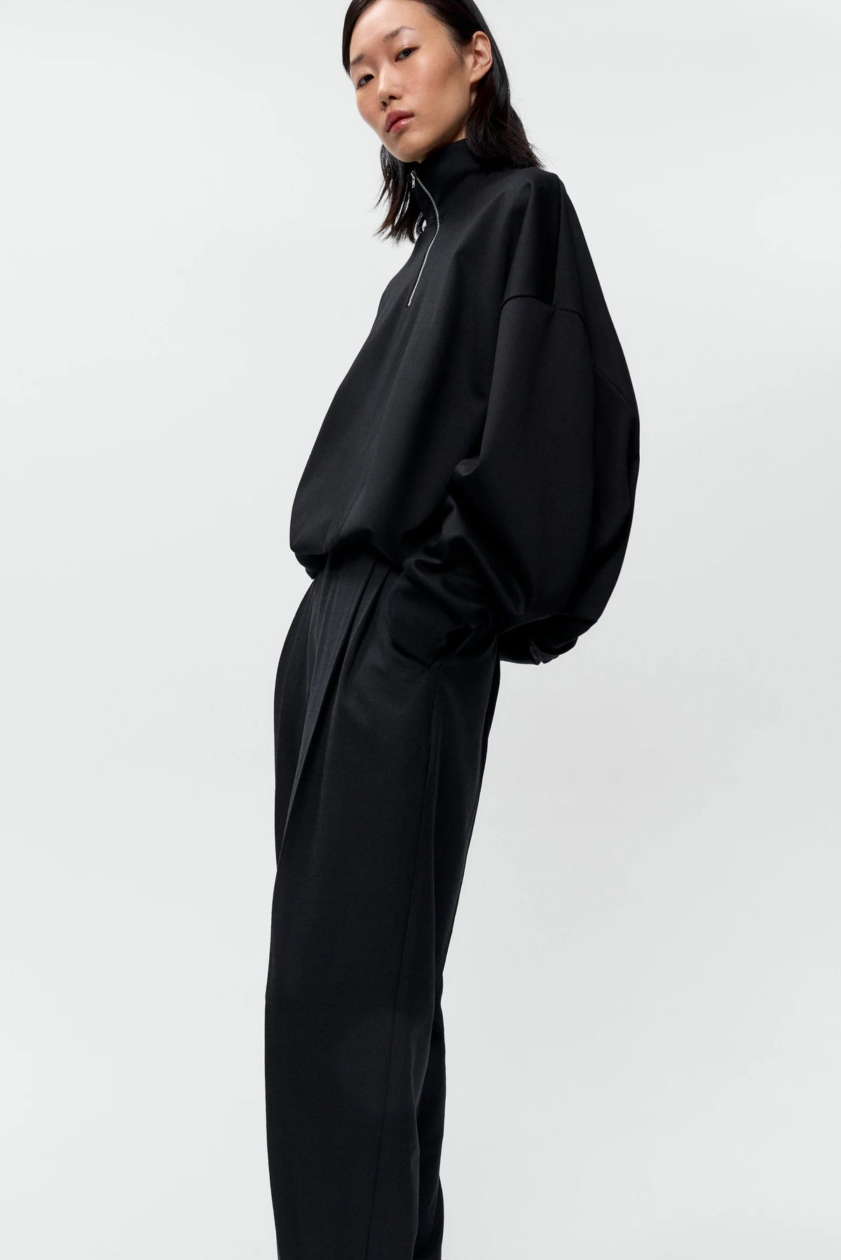 Person wearing a black outfit on a white background