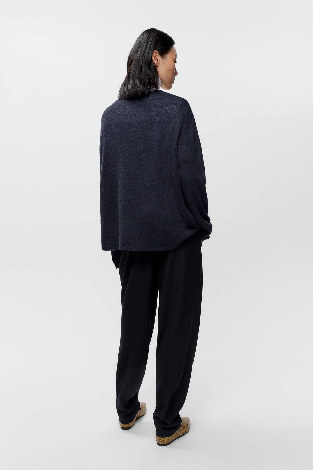 Person wearing a dark gray outfit on a white background