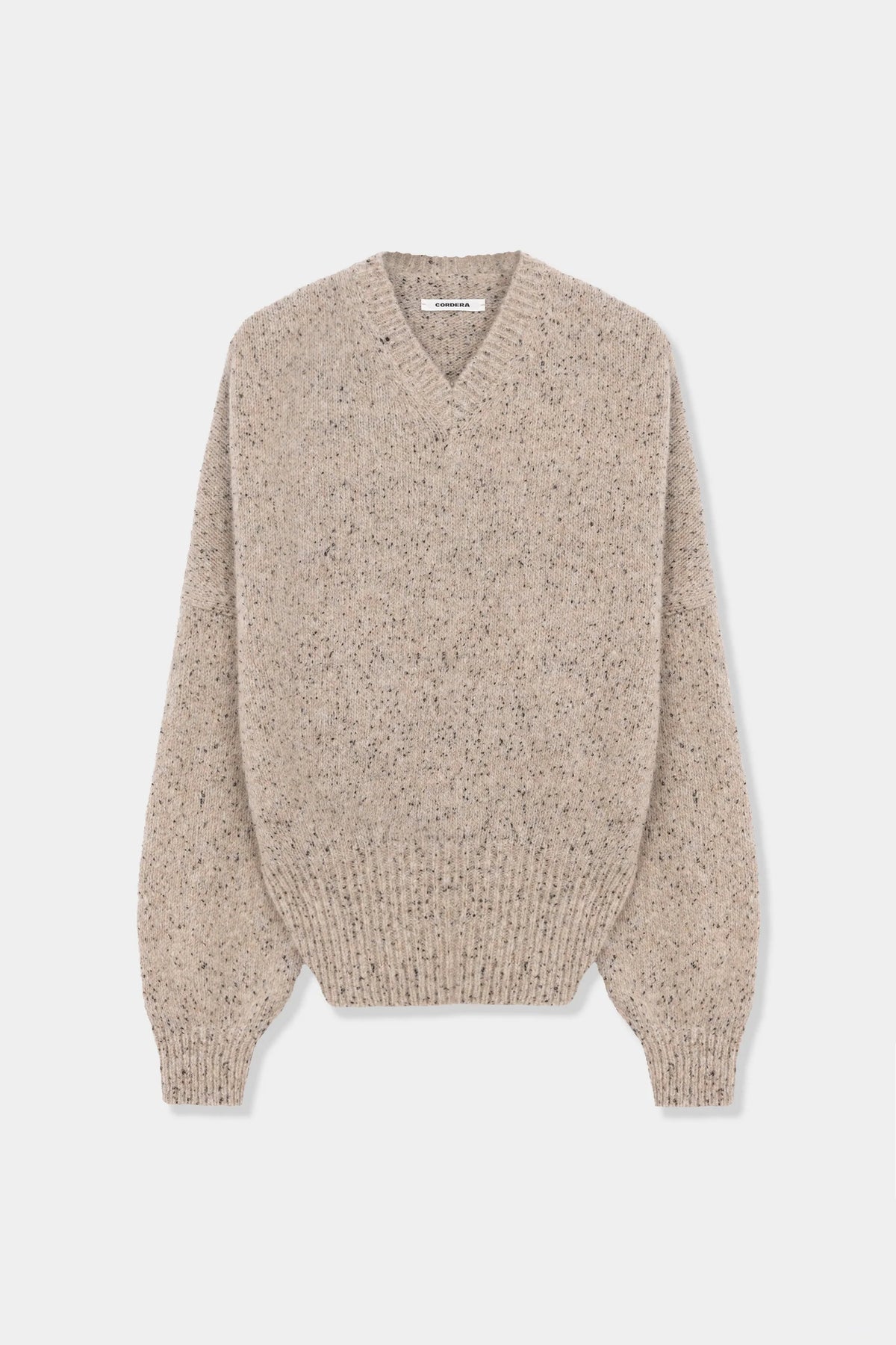 A beige and brown speckled knit sweater with a V-neck and long sleeves, displayed on a clean light gray background.