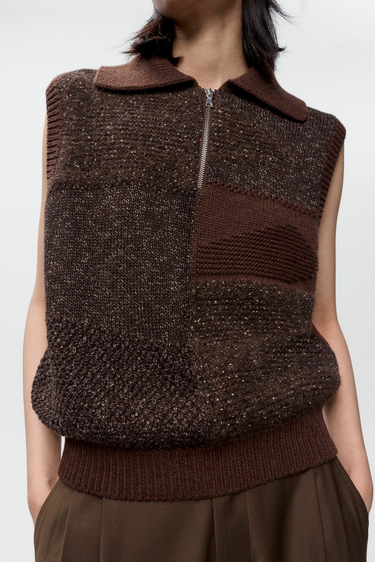 Brown knitted vest worn by a person on a white background