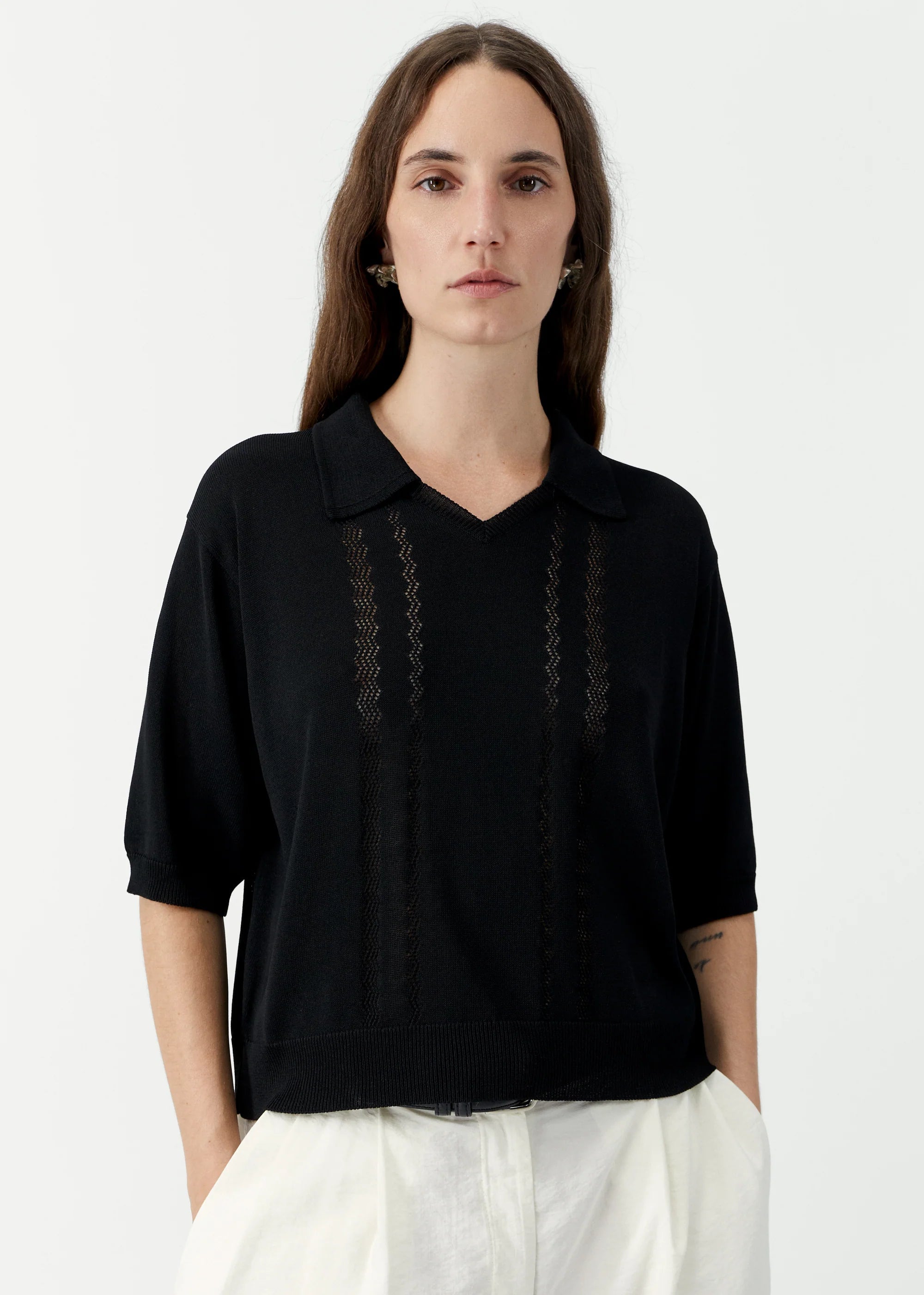 Woman wearing a black blouse with lace details on a white background