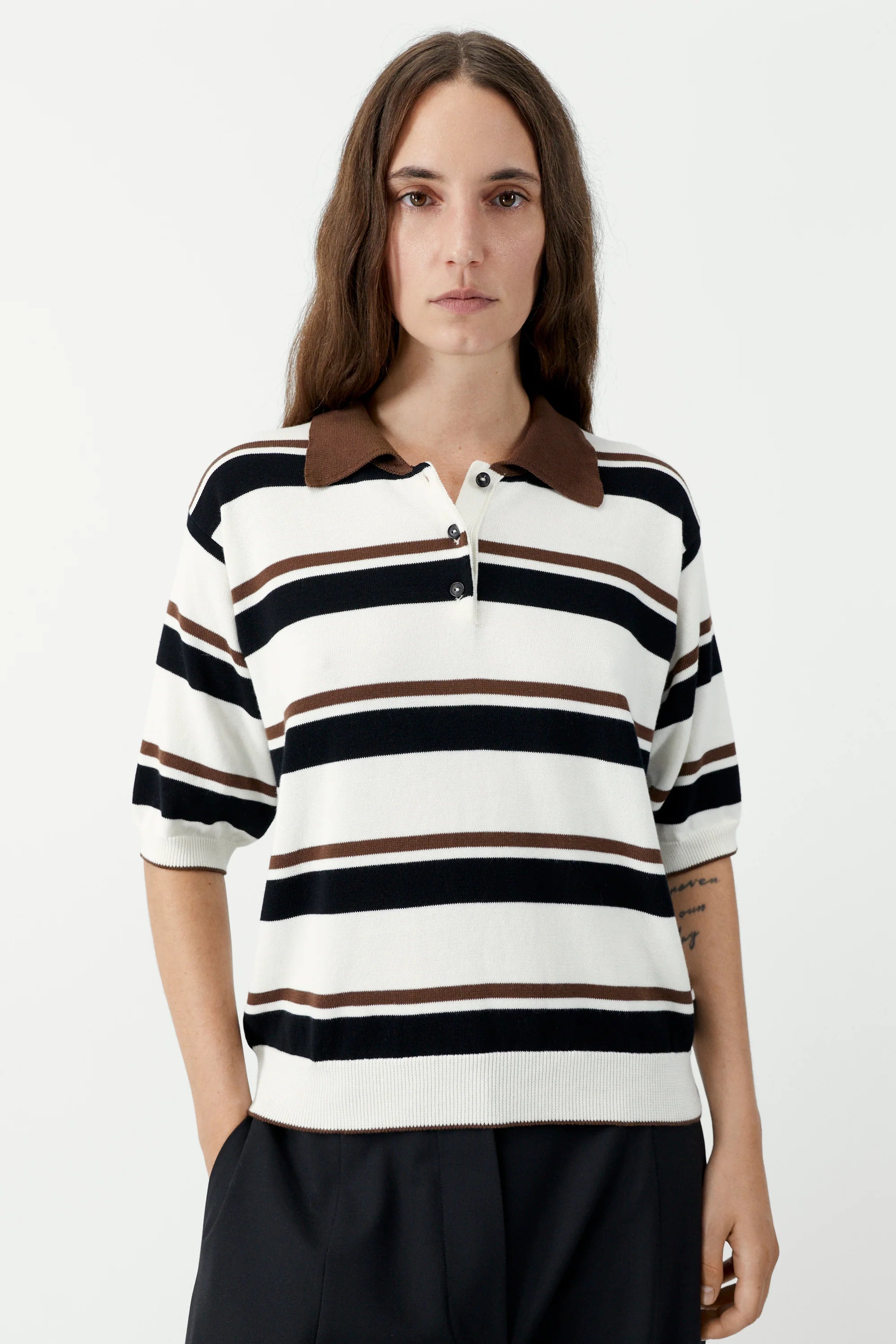 Woman wearing a striped shirt with a brown collar on a white background