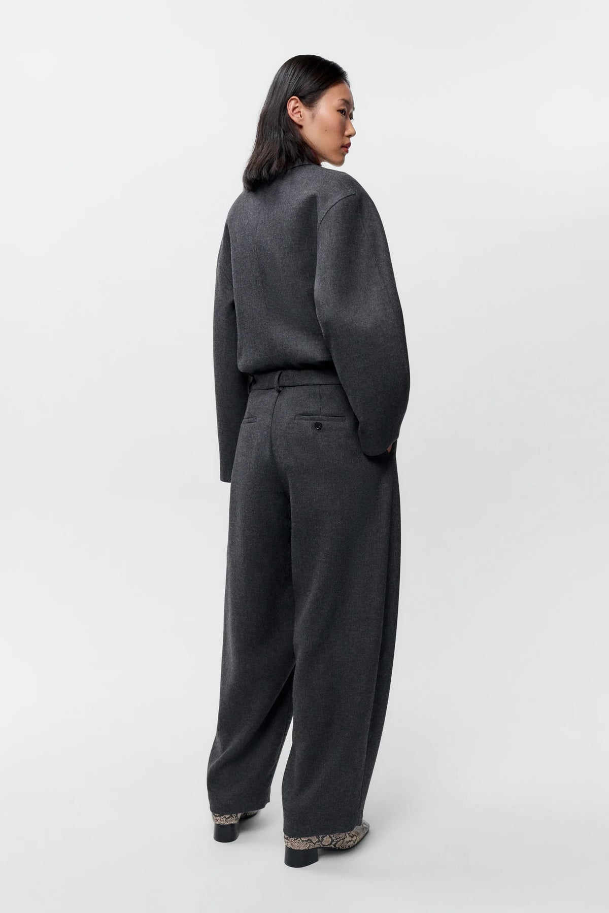 Person wearing a gray suit on a white background