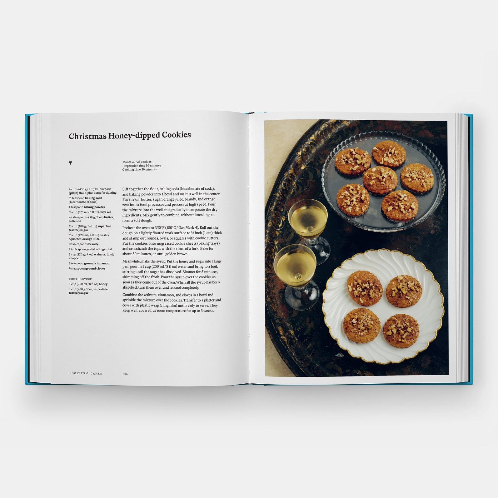 Open cookbook showing a recipe for Christmas Honey-dipped Cookies with a photo of cookies on a plate.