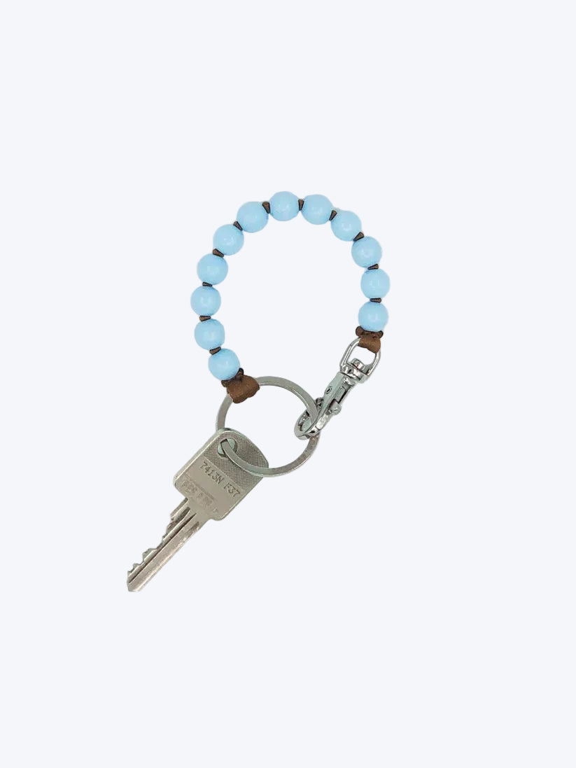 Keychain with blue beads and a key on a white background
