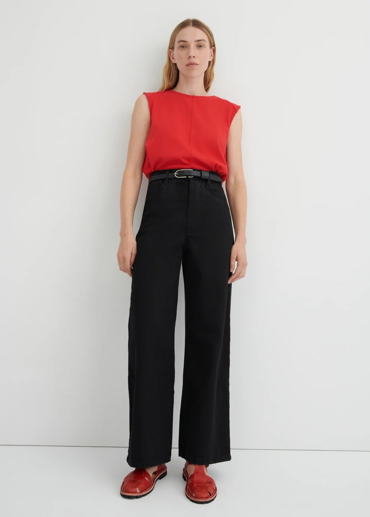 model in red top, black jeans, red shoes