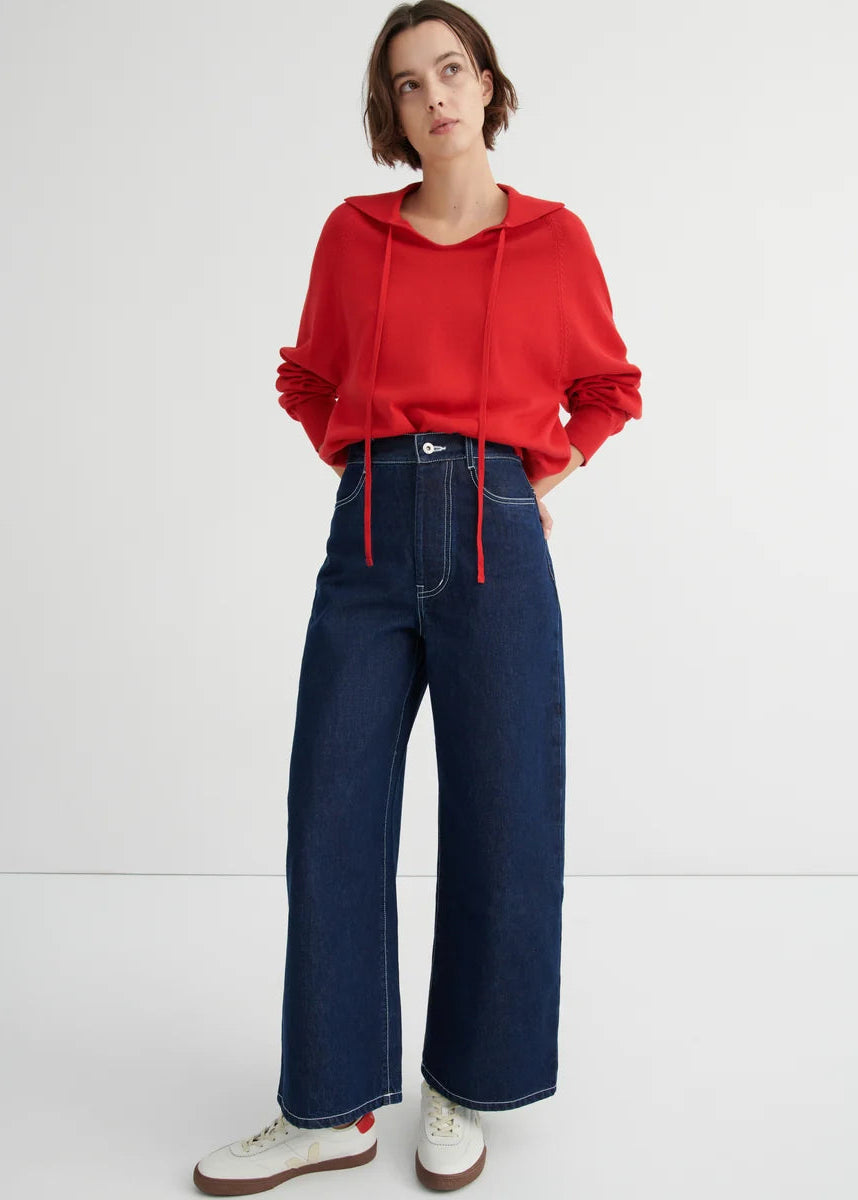 model wearing red sweater and jeans